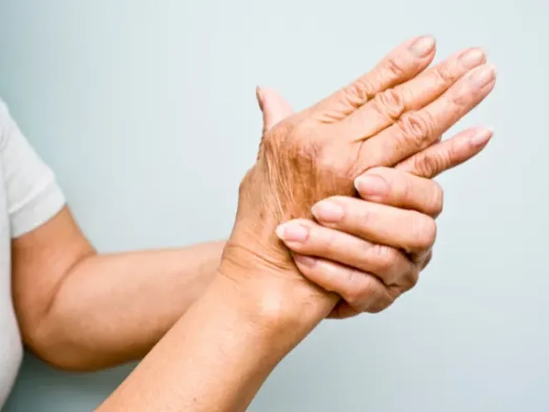 Hands massaging an older patient's hand and fingers