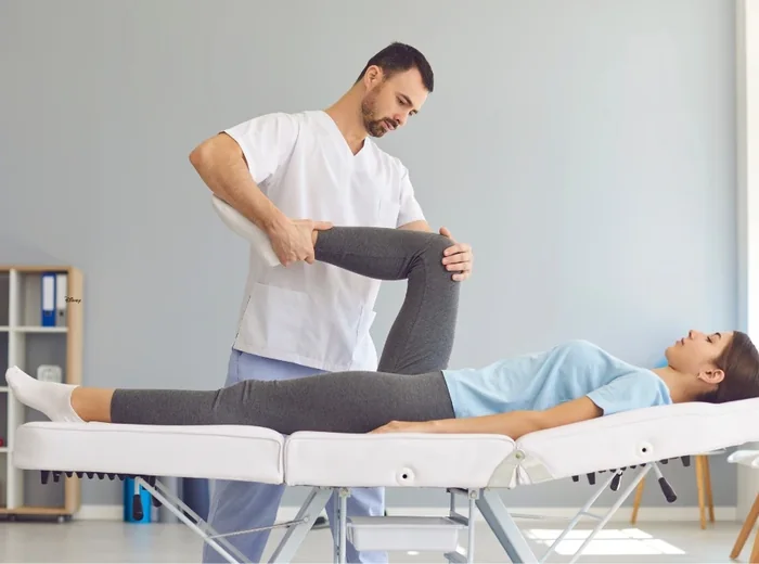 Therapist moving a patient's hip and knee through range