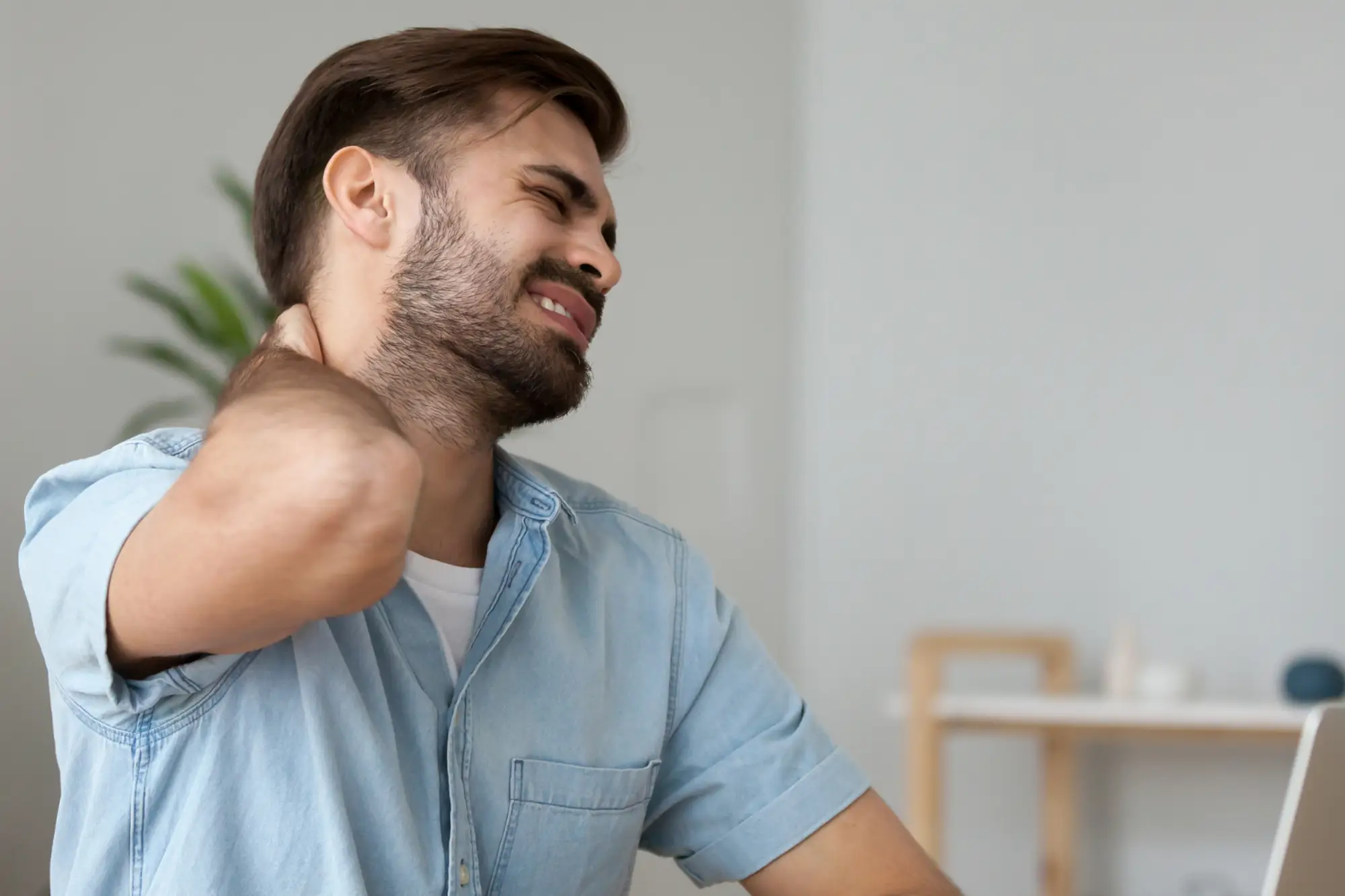 Man holding the back of his neck in pain