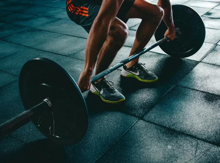 Athlete lifting a loaded barbell off the gym floor