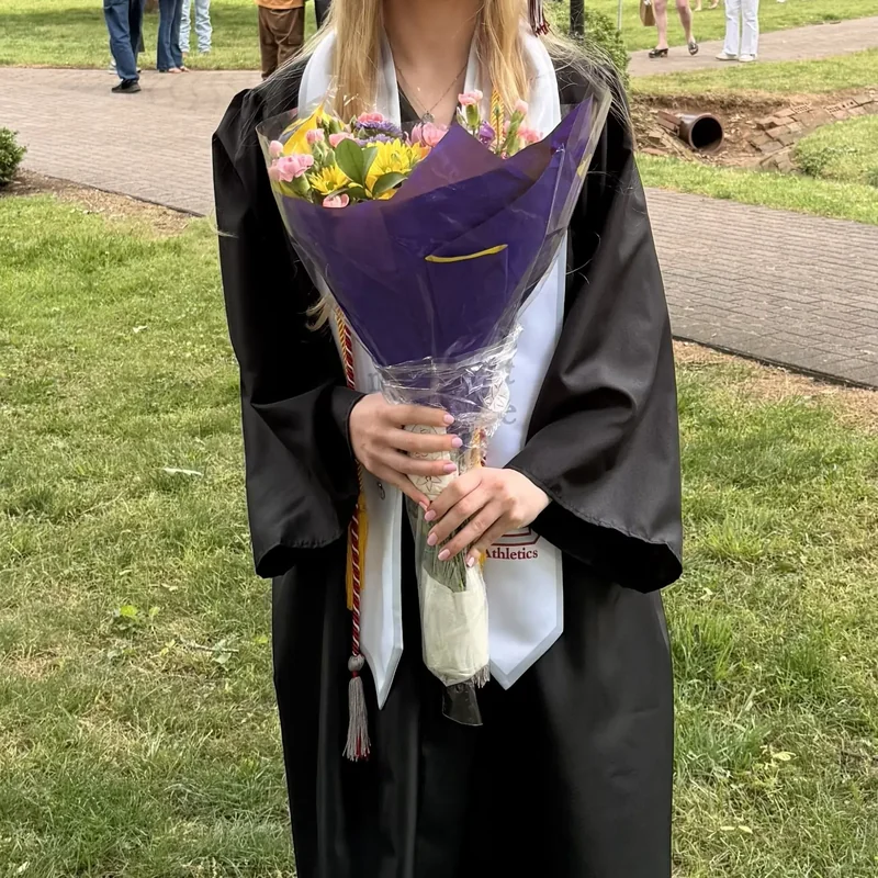 Grace Overton's Guilford College graduation gown, athletics stole and bouquet
